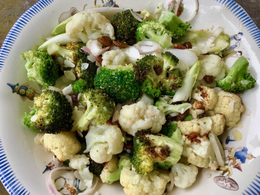 Een salade van bloemkool, broccoli en lof met een rozijnendressing